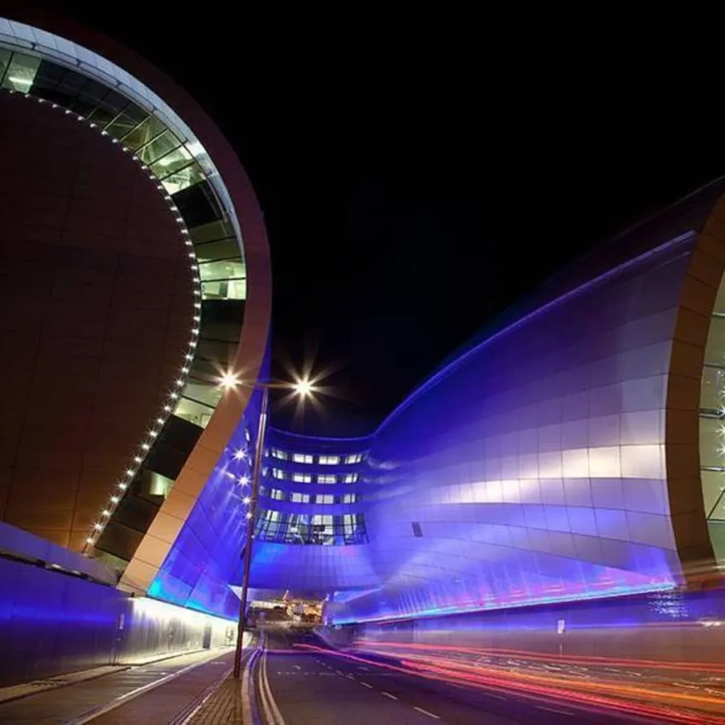 Night view of the road leading to Terminal 1 drop-off at Dublin Airport, featuring modern architecture and light trails.