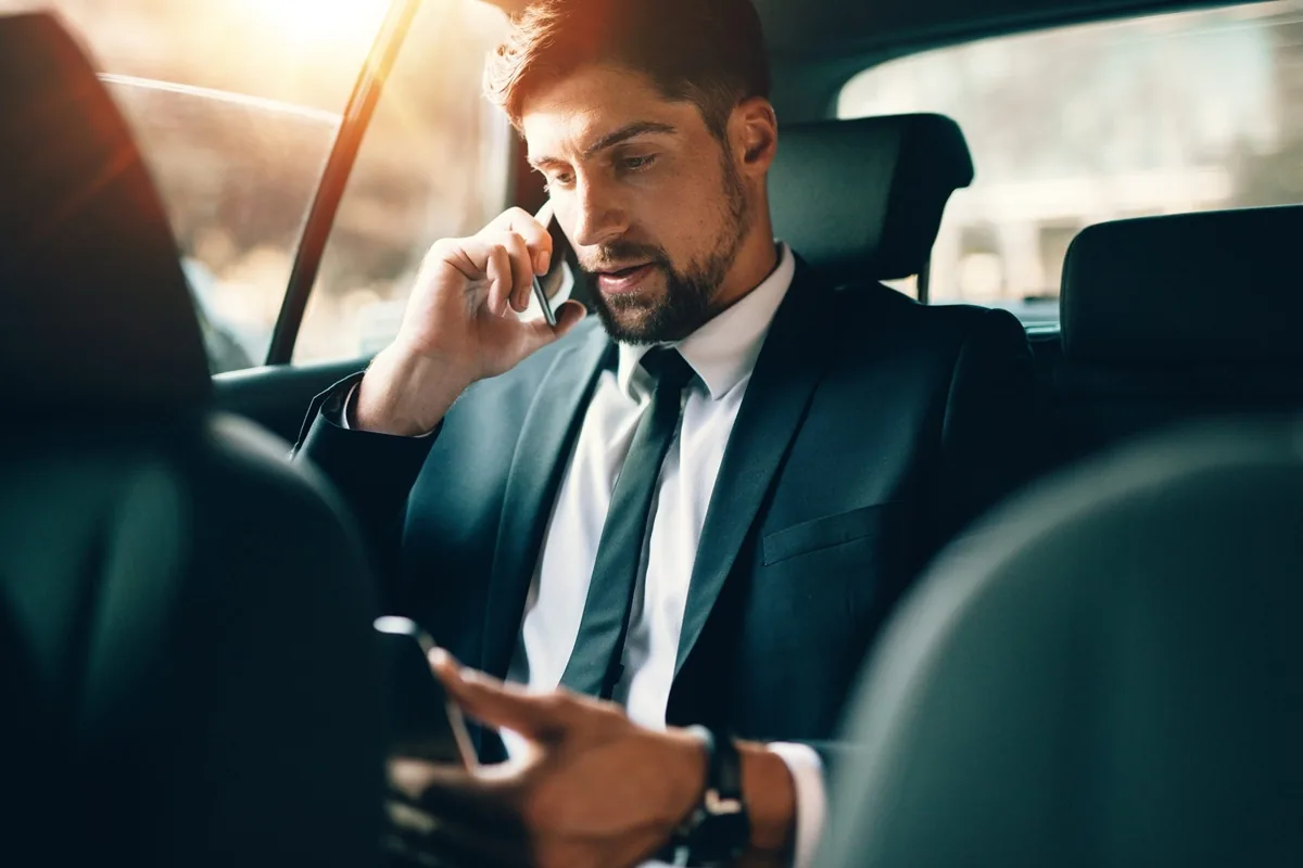 Businessman talking on the phone in a luxurious car