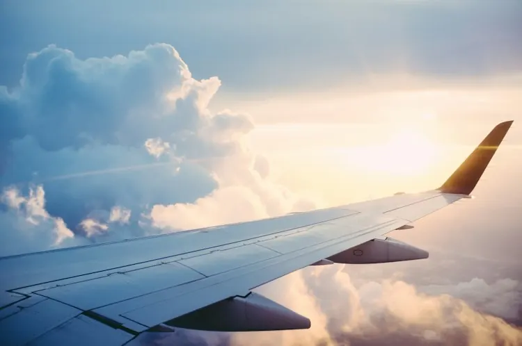 Aircraft wing above clouds, illustrative airport travel photo
